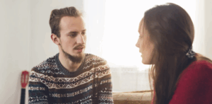 A man and a woman sit next to each other and engage in healthy fighting